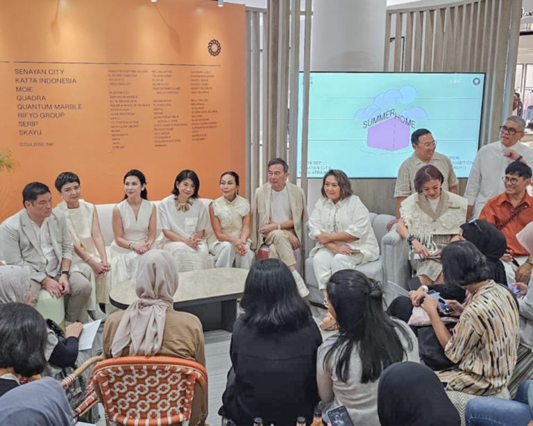 A panel discussion taking place in a modern talk show area, featuring speakers seated on elegant IKONS furniture.