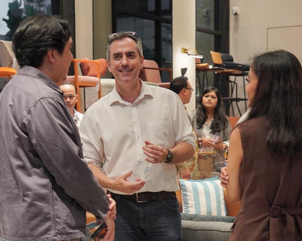 International and local guests engaged in conversations and enjoying the showroom atmosphere at Ikons Summer Soirée.